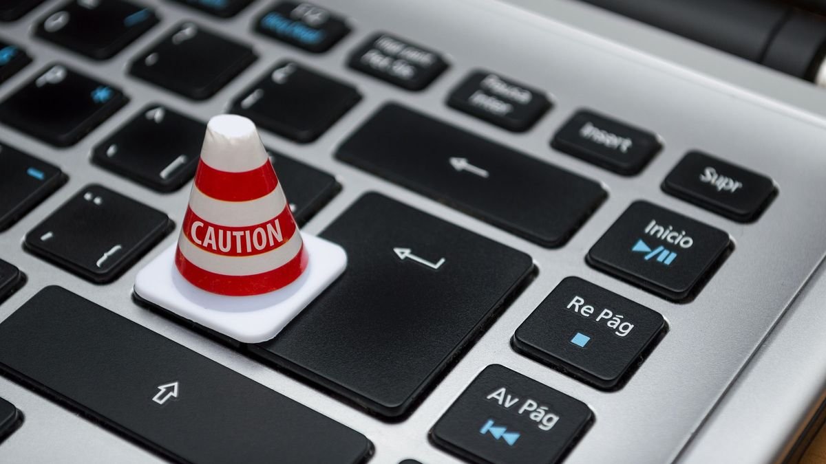 Мініатюрний конус із написом «Caution» на клавіатурі ноутбука