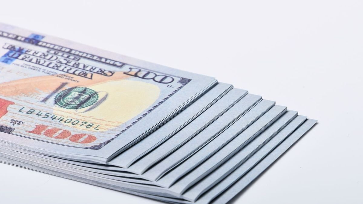Стос банкнот по 100 доларів США на білому тлі
